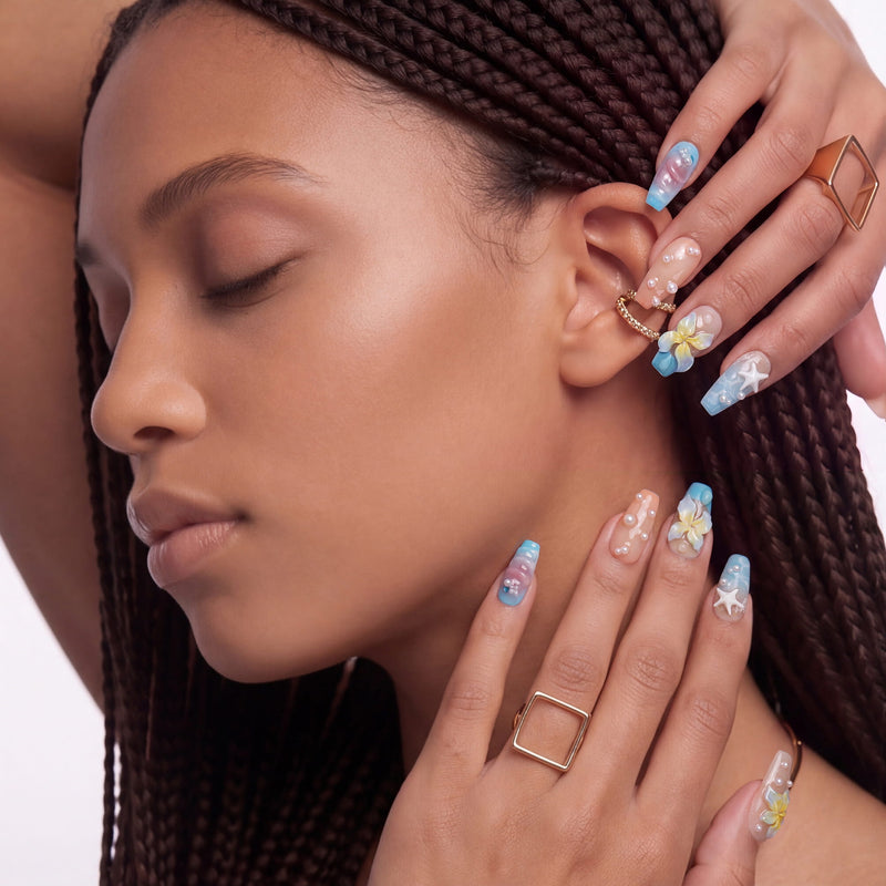A hand model wearing blue and yellow floral press-on nails beside a side profile portrait