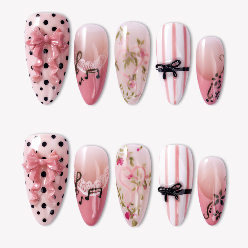 Parisian Charm press-on nails with pink bows, black polka dots, lace, floral art, stripes, and glossy pink tips