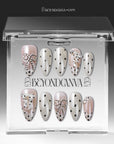 Parisian Polka press-on nails in ivory and blush with black polka dots and pearl chain accents displayed in a clear packaging box