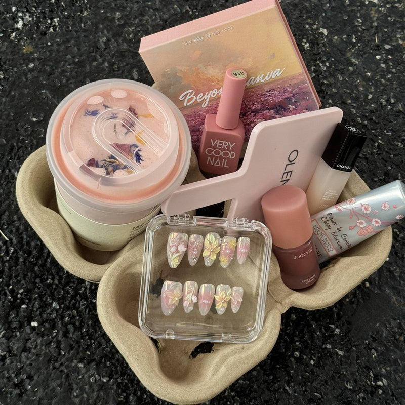 Pastel Bloom press-on nail set displayed with pink beauty products, a mirror and drink carrier