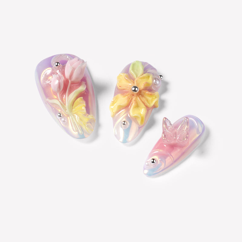 Close-up of Pastel Bloom pink and blue nails with sculpted tulips, yellow flowers and a clear butterfly charm