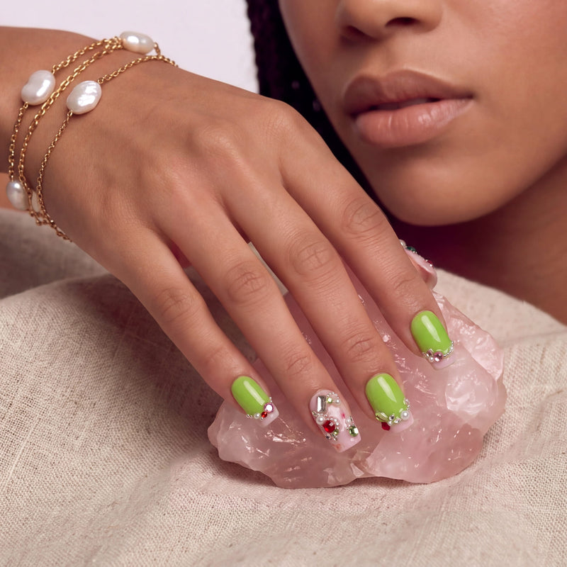 Pastel Dream handmade press-on nails worn in a close-up portrait with lime green nails, crystals, and pearl jewelry