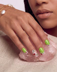 Pastel Dream handmade press-on nails worn in a close-up portrait with lime green nails, crystals, and pearl jewelry