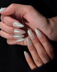 Pearl white iridescent press-on nails arranged in a set layout