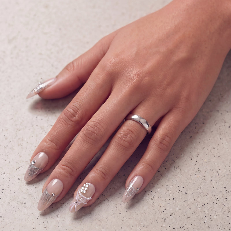 Hand model wearing Pearl Cascade press-on nails in nude and silver with pearl and crystal accents