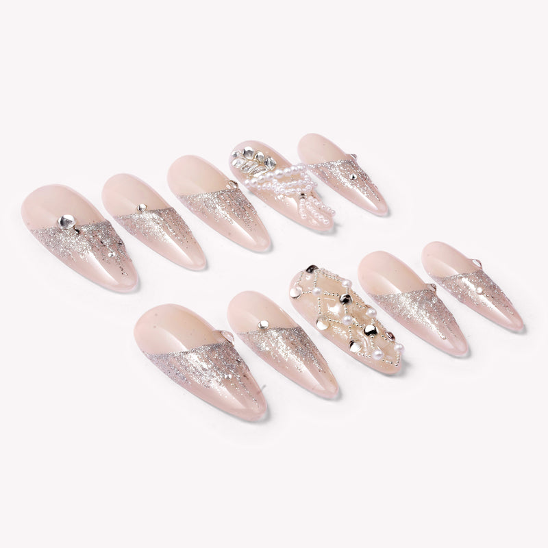 Pearl Cascade press-on nails in nude and silver with pearl and crystal accents arranged in a flat lay on a white background