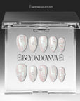 Branded acrylic packaging display showing pale blush pearlescent nails arranged in two rows.