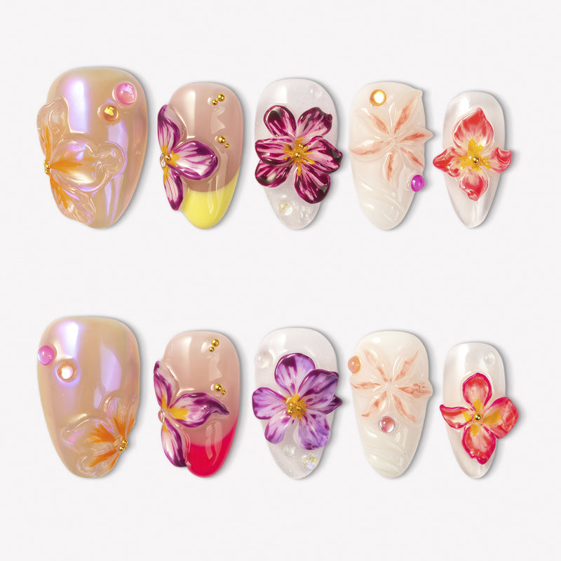 Petal Poem colorful press-on nails with raised purple, pink, peach and yellow flower designs in a white flat lay