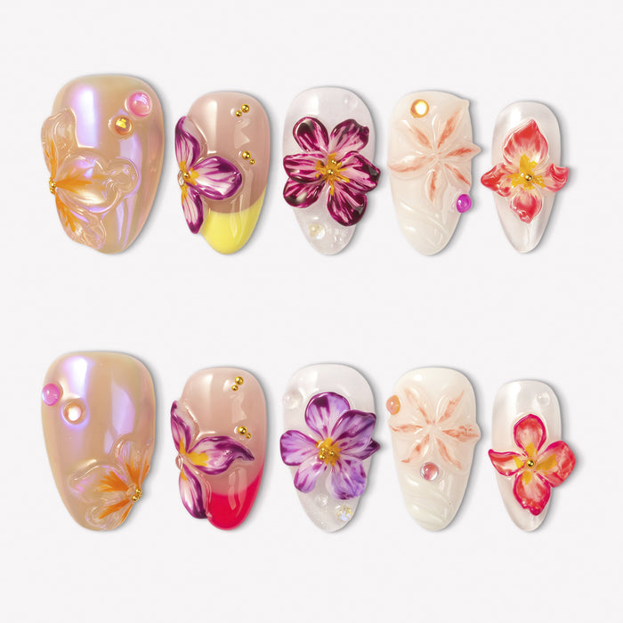Petal Poem colorful press-on nails with raised purple, pink, peach and yellow flower designs in a white flat lay