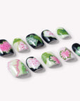 Individual Pink Caladium press-on nails arranged on a white background with black, pink, green, and cream leaf patterns