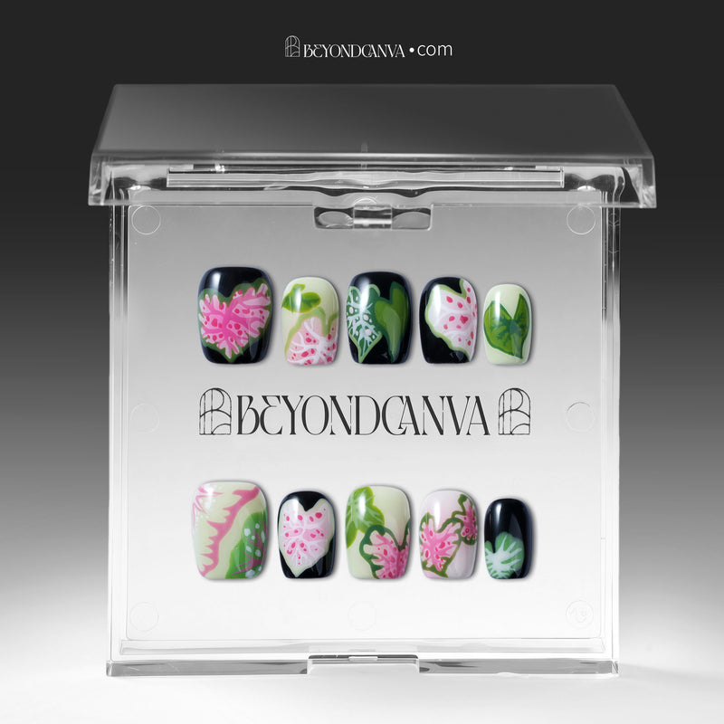 Pink Caladium press-on nails displayed in a clear Beyondcanva packaging case with floral leaf designs inside