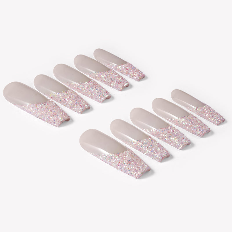Flat lay of Pink Confetti press-on nails with sheer nude pink bases and sparkling pink silver glitter French tips