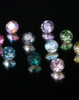Assortment of premium cubic zirconia crystals in pink, blue, green, lavender, and gold on a black background