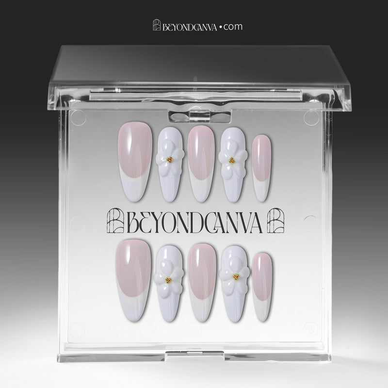 Press-on nails displayed in a clear BeyondCanva case with pale pink and white nails and 3D white flower accents.