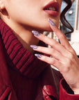 Close-up of Purple Dream lavender floral press-on nails beside a model's lips and red leather jacket