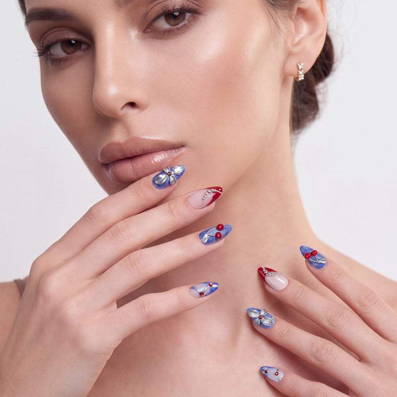 Rebel Cherry handmade press-on nails in a close-up portrait with blue accents, silver bows, and red cherry details