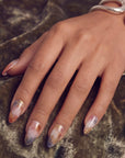 Close-up of a hand model wearing Rose Veil Aureate press-on nails with blush pink, ivory, and gold foil accents