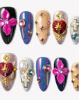 Saint of Desire press-on nails with pink flowers, red heart charms, gold cross accents, pearls, and colorful gemstones