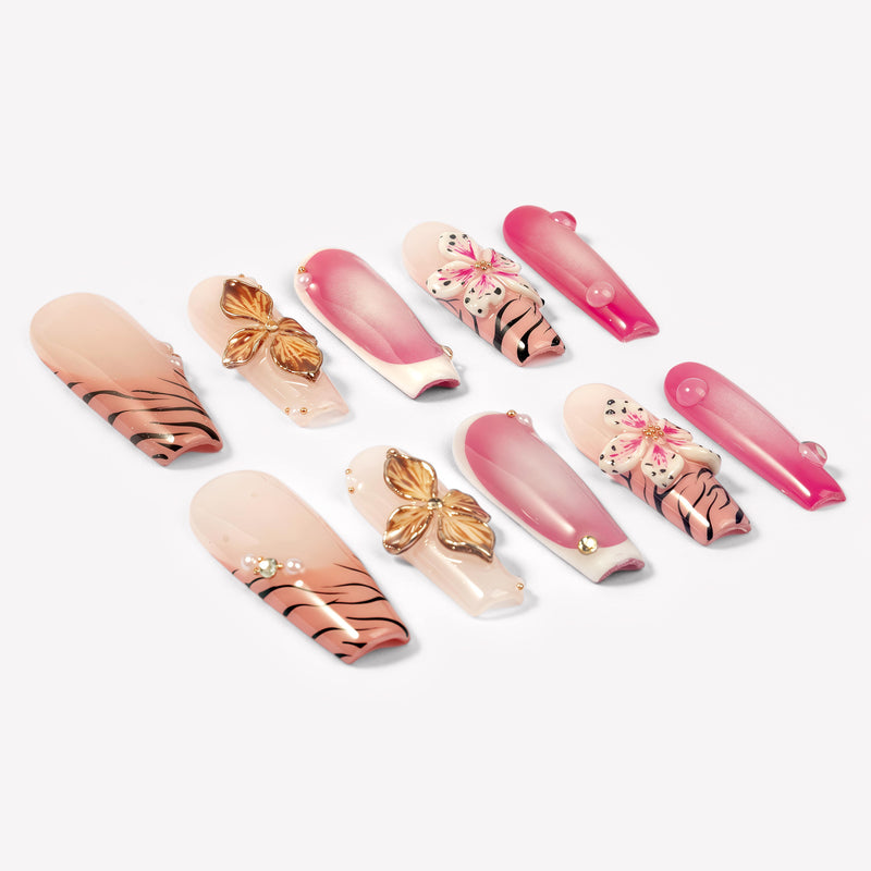 Angled flat lay of Sakura Blaze pink and nude nails with gold flowers, sakura blooms and pearls