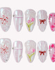 Sakura Whisper pearly pink and white press-on nails with cherry blossoms, tulips, plaid lines, bows and silver studs