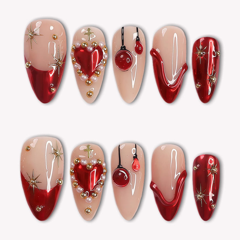 Scarlet Heart Oath press-on nails in nude, deep red, and gold with heart and starburst accents arranged in a flat lay