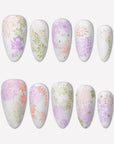 Secret Garden press-on nails with pastel pink, lavender, and sage floral patterns on a white flat lay background