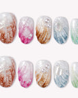 Set of multicolor pearl-textured press-on nails with shell-like finish in brown, pink, gold, blue, and green.
