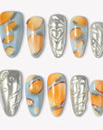 Solar Pulse orange, pale blue and silver press-on nails with chrome hearts, swirls and bead accents