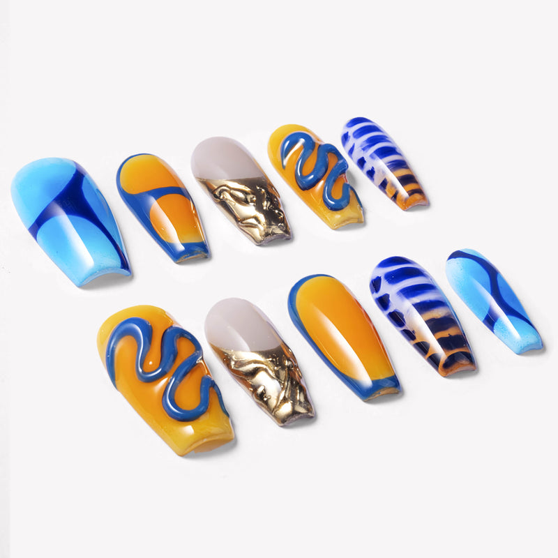 Angled flat lay of Solar Tide press-on nails with blue and orange wave art, striped accents, and metallic gold marbling