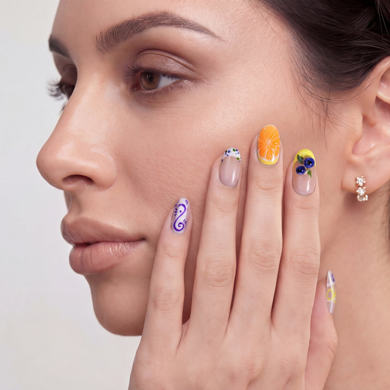 Close-up portrait of a woman wearing colorful floral and fruit-inspired press on nails