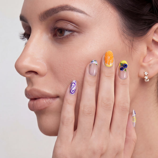 Close-up portrait of a woman wearing colorful floral and fruit-inspired press on nails