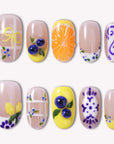 South Holiday press on nails with colorful floral and fruit-inspired details arranged in a flat lay on a white background