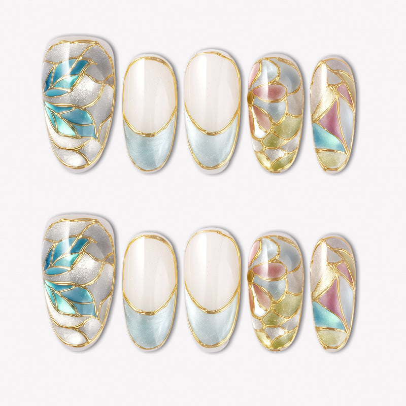 Stained Glass Leaves press-on nails with blue, cream, pink, and green translucent leaf panels, raised gold outlines, and glossy shimmer finish