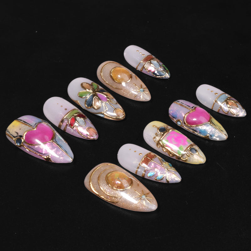 Stained glass press on nail set arranged in a flat lay on a black background