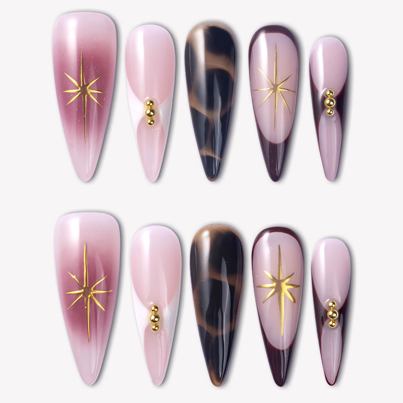 Starlit Mocha press-on nails with pink shimmer, black mocha cat-eye accents, gold starbursts, and bead details