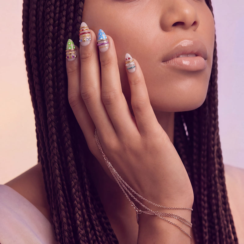 Sunset Gypsy handmade press-on nails worn in a close-up portrait with colorful decorative accents and gold details