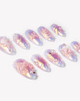 Angled flat lay of Swan Ballet iridescent blue pink nails with pearls, bows and sculpted white swan accents