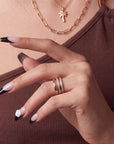 Close-up hand model wearing Timeless Serenity press-on nails with nude bases, black French tips, subtle shimmer, and a white 3D flower
