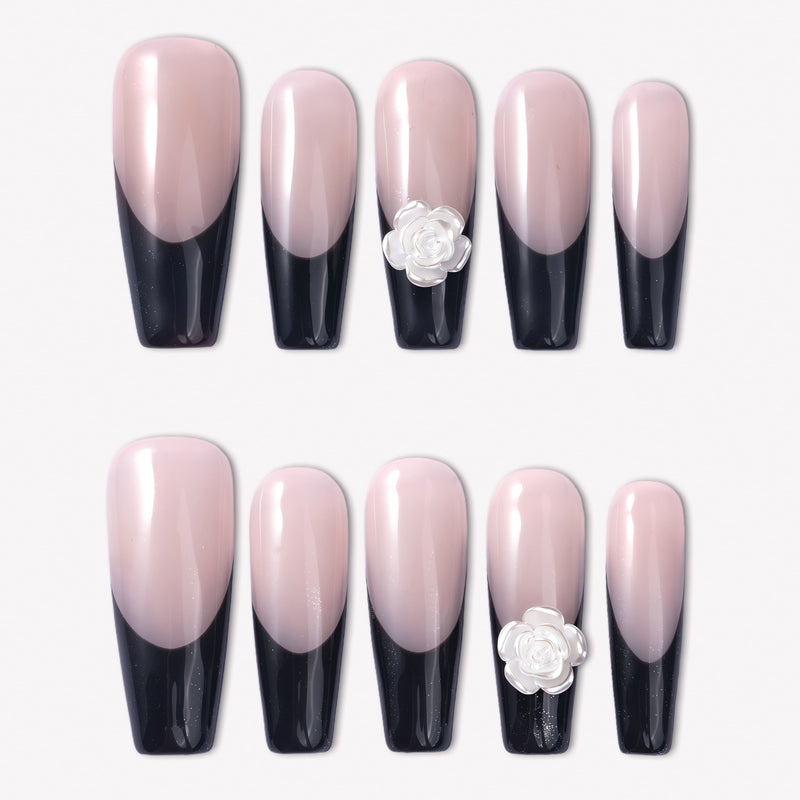 Timeless Serenity press-on nails with glossy nude bases, black French tips, subtle shimmer, and white 3D flower accents arranged in a full set
