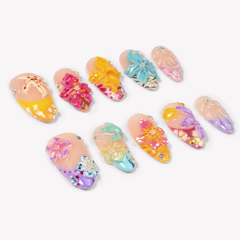 Angled flat lay of Tropical Bloom colorful press-on nails with raised tropical flowers, shells and gems