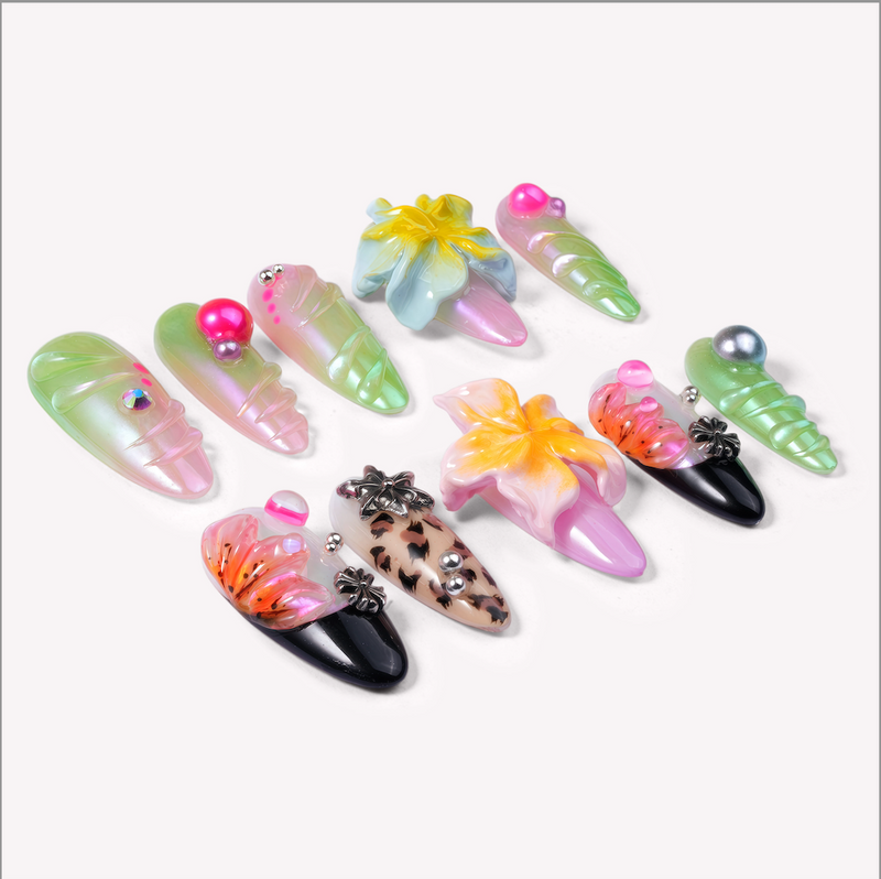 Diagonal flat lay of Tropical Cyber-Shell handmade press-on nails with neon green, pink, yellow, black, and floral accents.