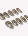 Flat lay of beige and brown snakeprint press-on nail tips arranged on a white background