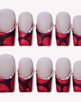 Flat lay of Vintage Ruby press-on nail swatches with glossy red and black bases and pearl accents