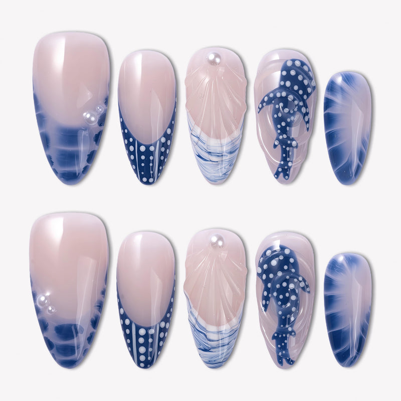 Whale Song press-on nails with blue ocean wave tips, whale tail design, white dot accents, seashell texture, pearl details, and glossy nude bases
