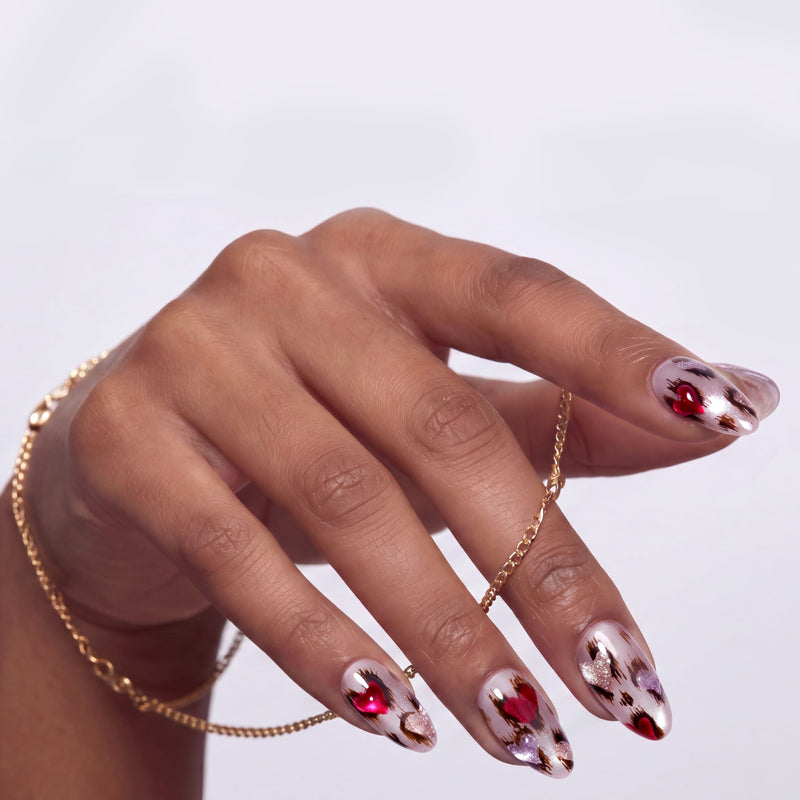 Close-up of a hand model wearing red and white marble press-on nails