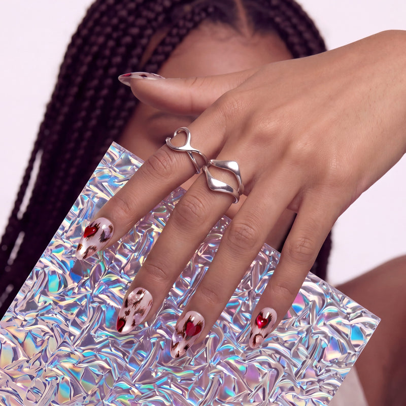 Portrait of a hand model wearing red and white marble press-on nails