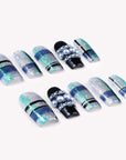 Diagonal flat lay of Winter Gridlight press-on nails with silver glitter, aqua blue, black, and pearl accents