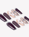 Angled flat lay of Winter Serenade press-on nails with deep purple rhinestone tips, textured accents, nude plaid lines, and white 3D flowers